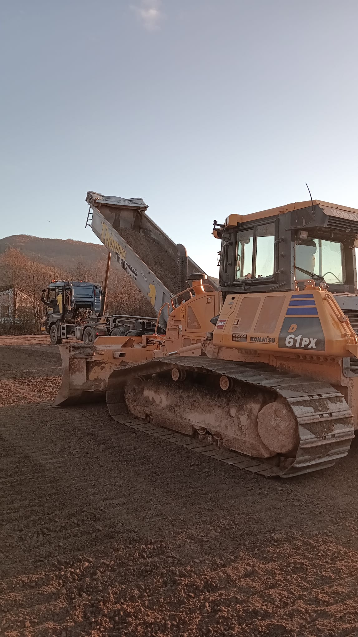 Komatsu Bulldozer D61PX und Kipper auf Baustelle
