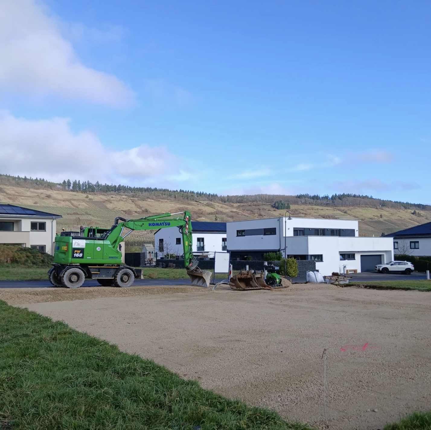 Komatsu Bagger bei sonnigem Wetter – Neubaugebiet