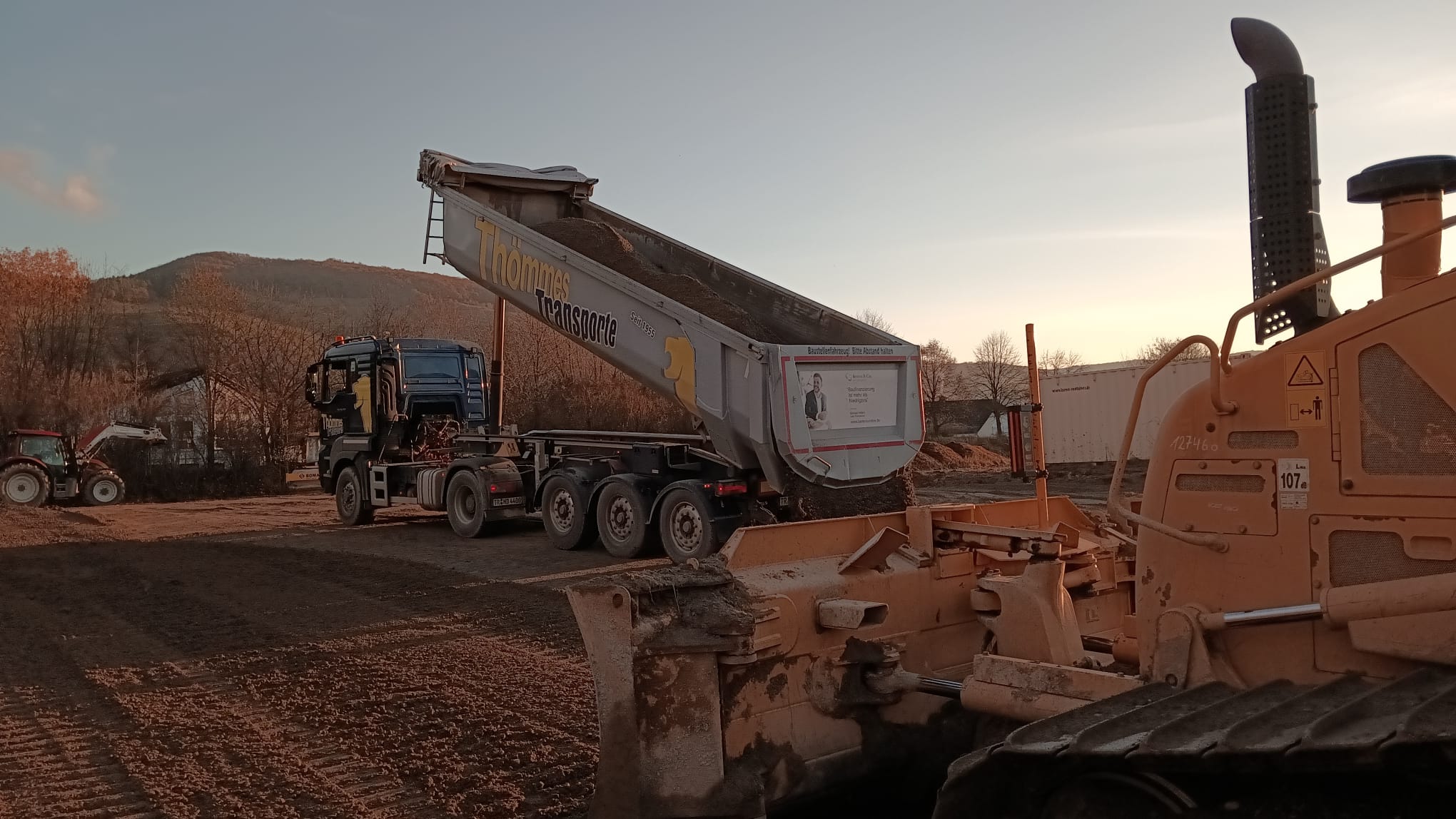 Kipper und Bulldozer bei Abendstimmung